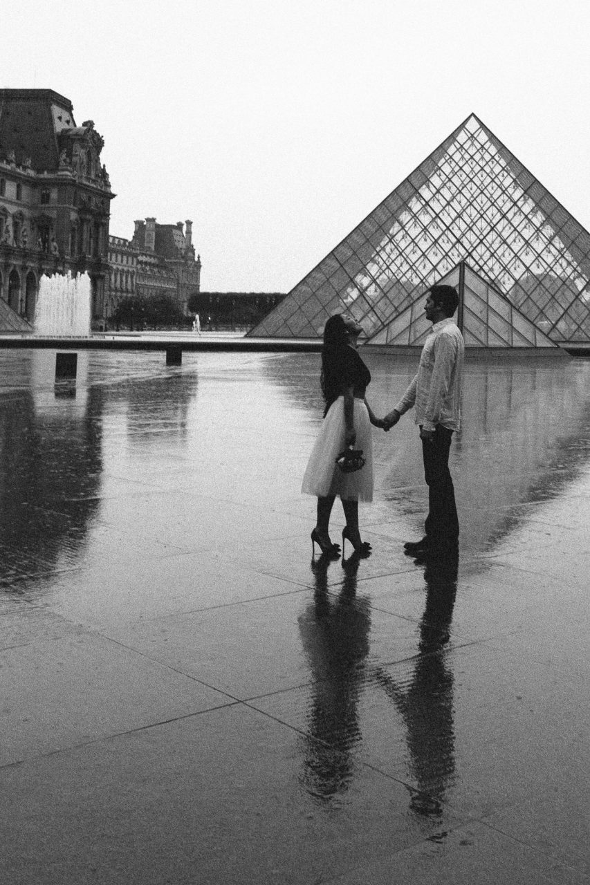 Couple black and white in the rain Pyramid Louvre Paris