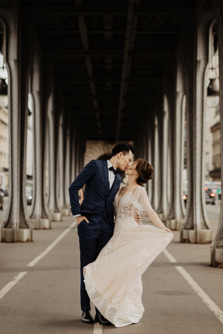 Bride and groom kissing on Bir Hakeim bridge