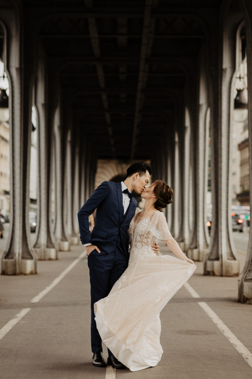 Bride and groom kissing on Bir Hakeim bridge