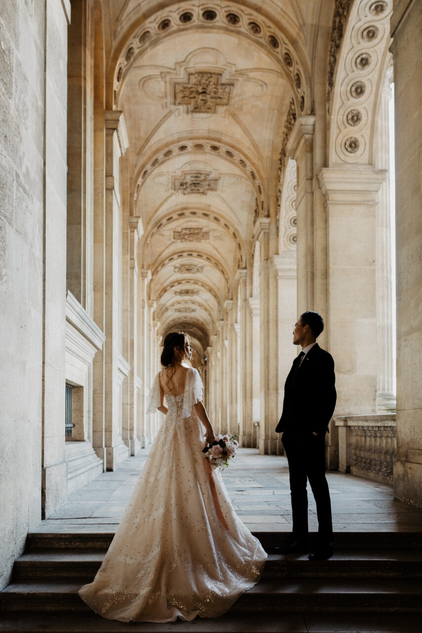 Bride and groom standing in Louvre museum for Paris wedding