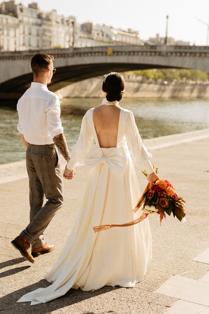 Bride and groom walking by the Seine paris wedding
