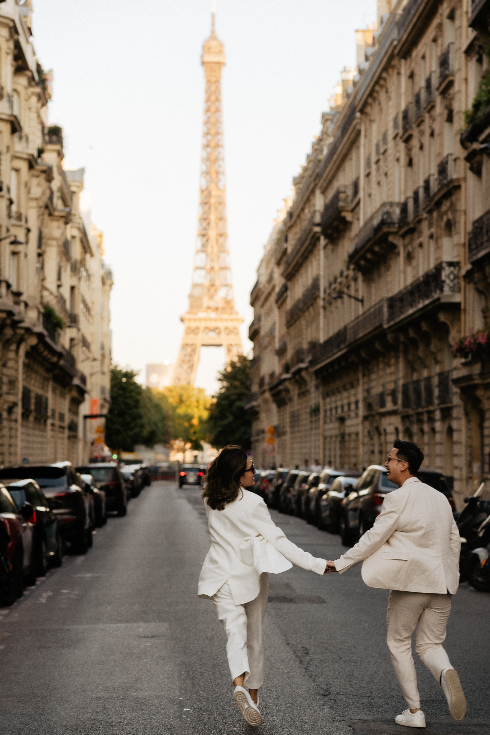 Couple running toward eiffeil tower photoshoot engagement