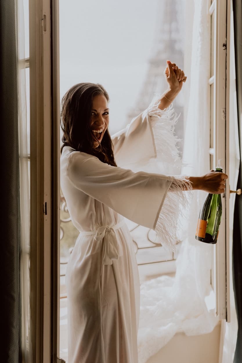bride popping champagne in front of Eiffel tower paris wedding at shangrila photographer