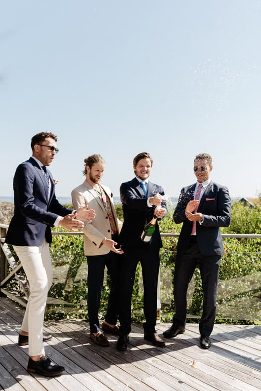 Champagne popping Celebration groomsmen wedding day photos