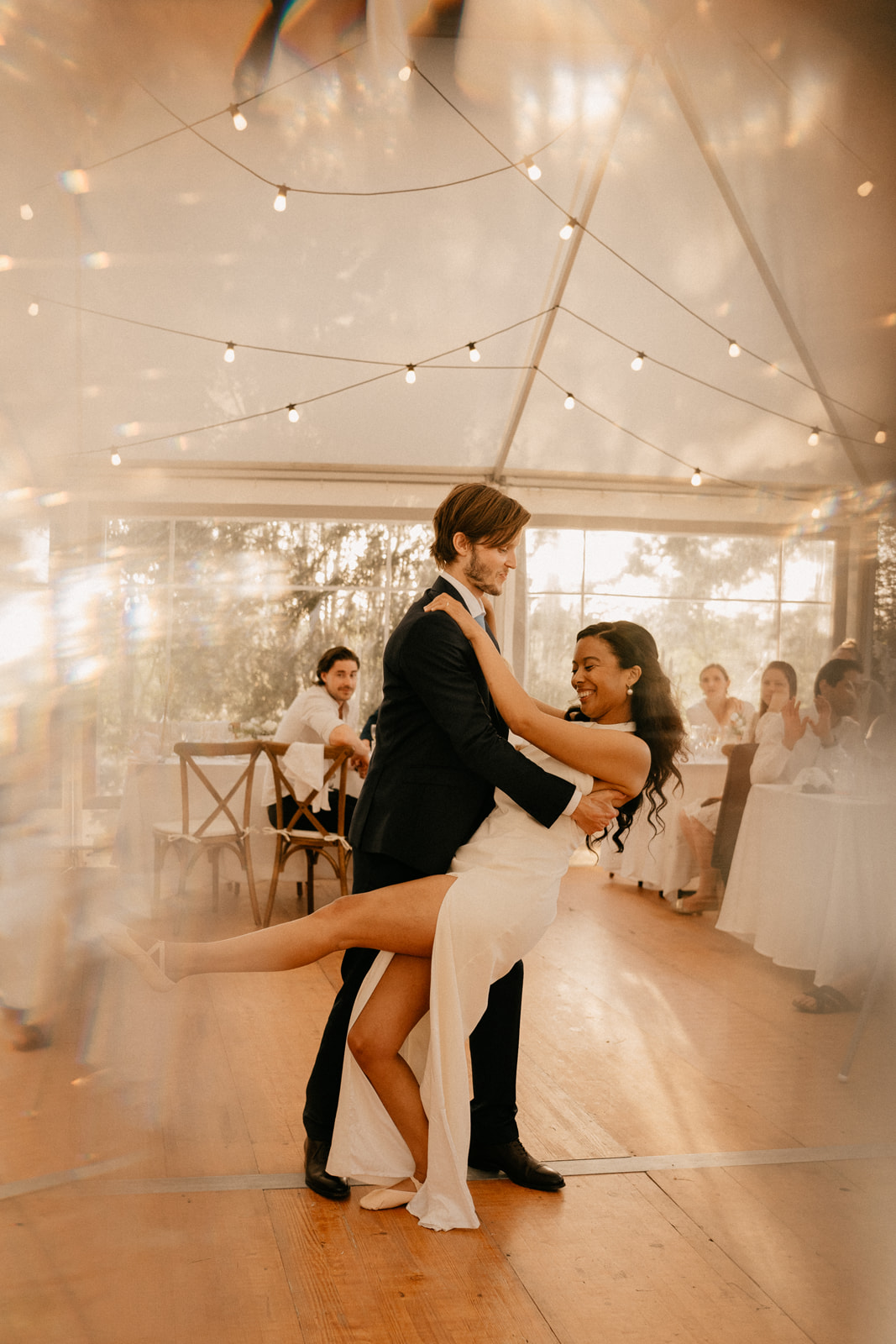 Bride and grooms first dance in chic boho wedding reception with fairy lights