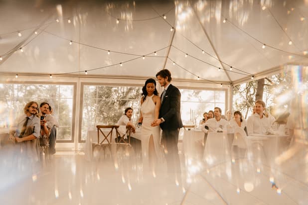 Bride and grooms first dance in chic boho wedding reception with fairy lights