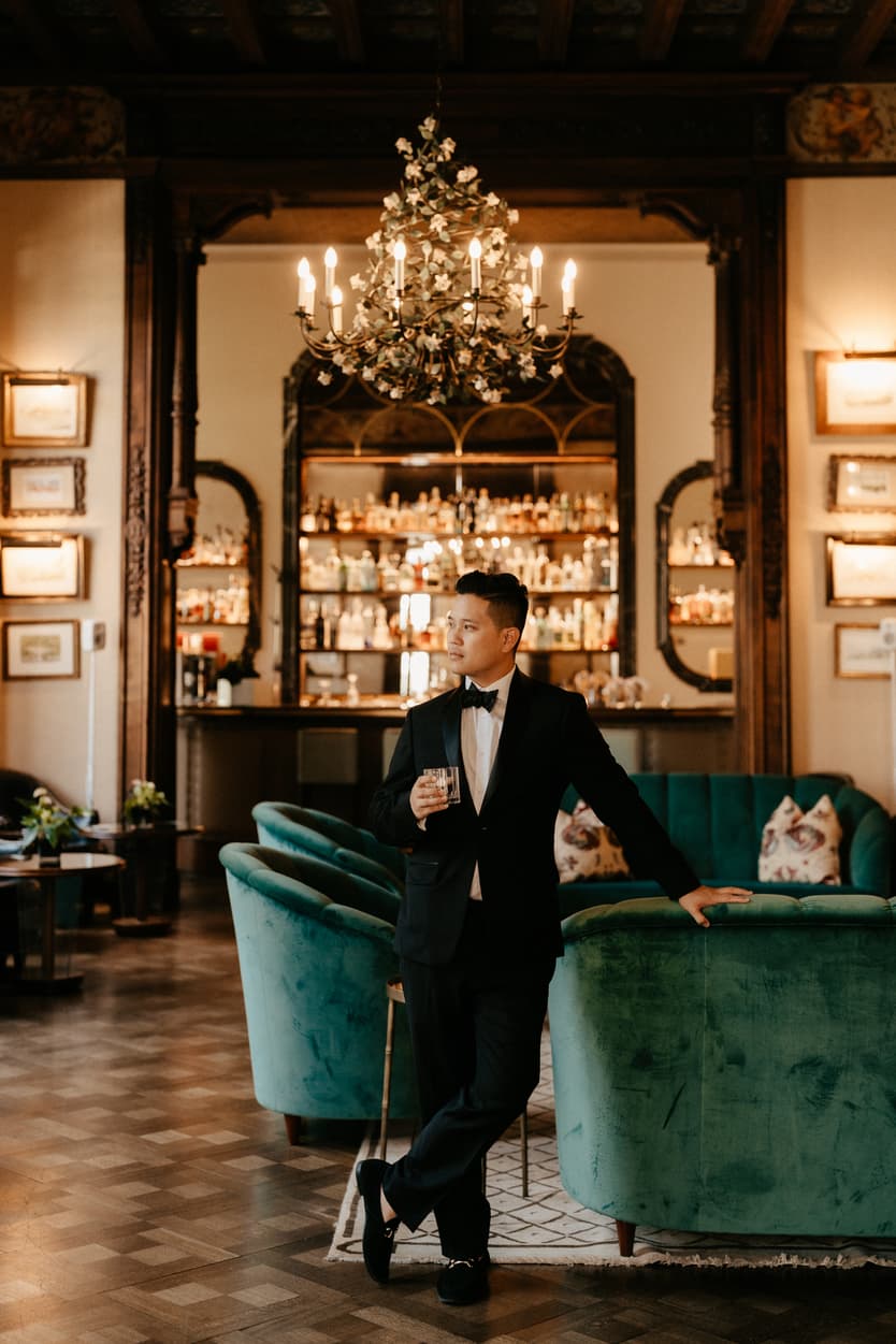 Elopement wedding Mandarin Oriental groom drinking and preparing at the bar Italy destination wedding photographer videographer