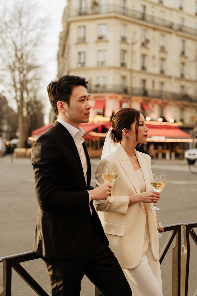 Couples Sunset Pre-wedding Photoshoot holding wine in Paris café Street 