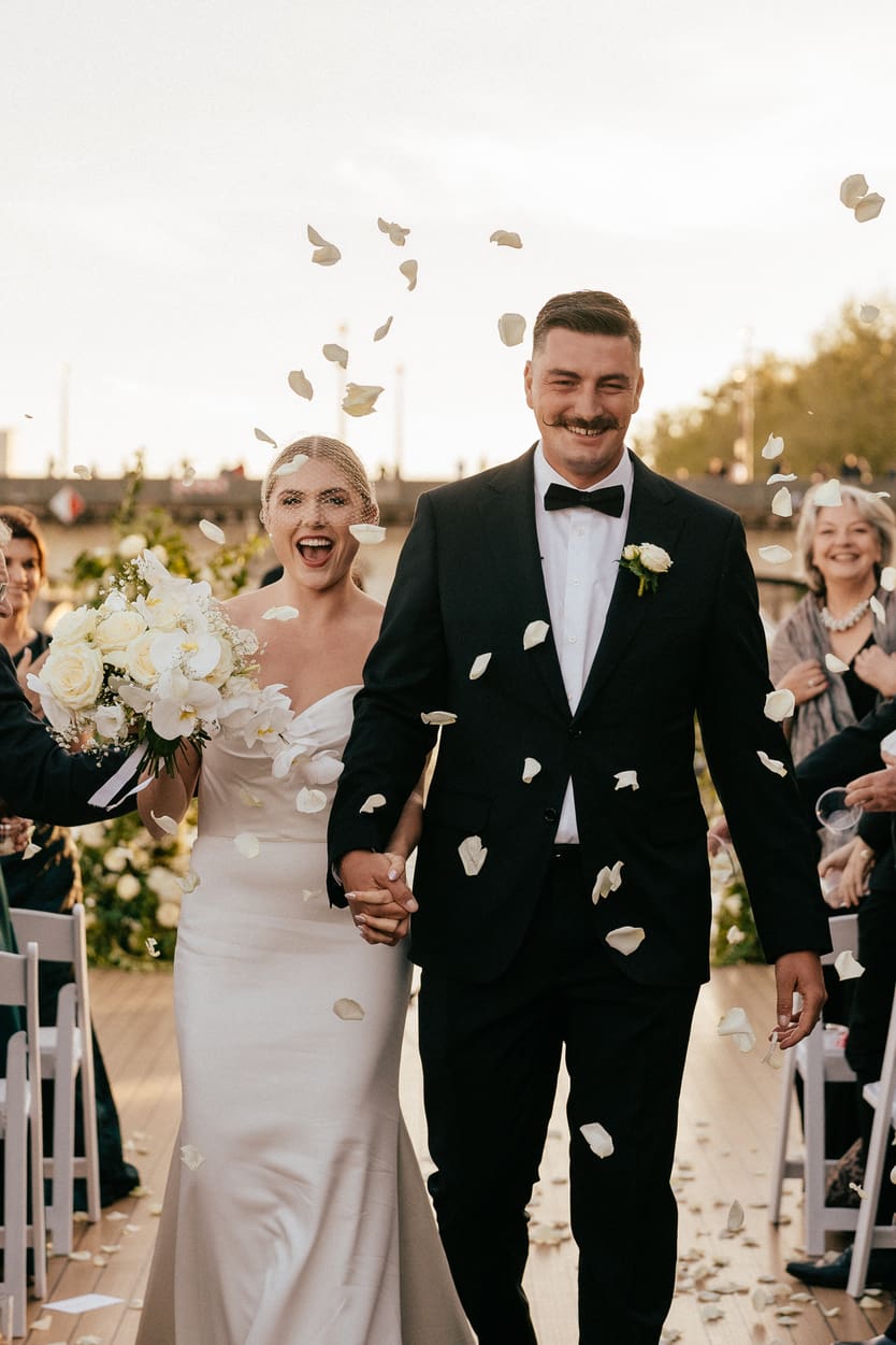 Couple walking out wedding exit with petal toss - Paris photographer