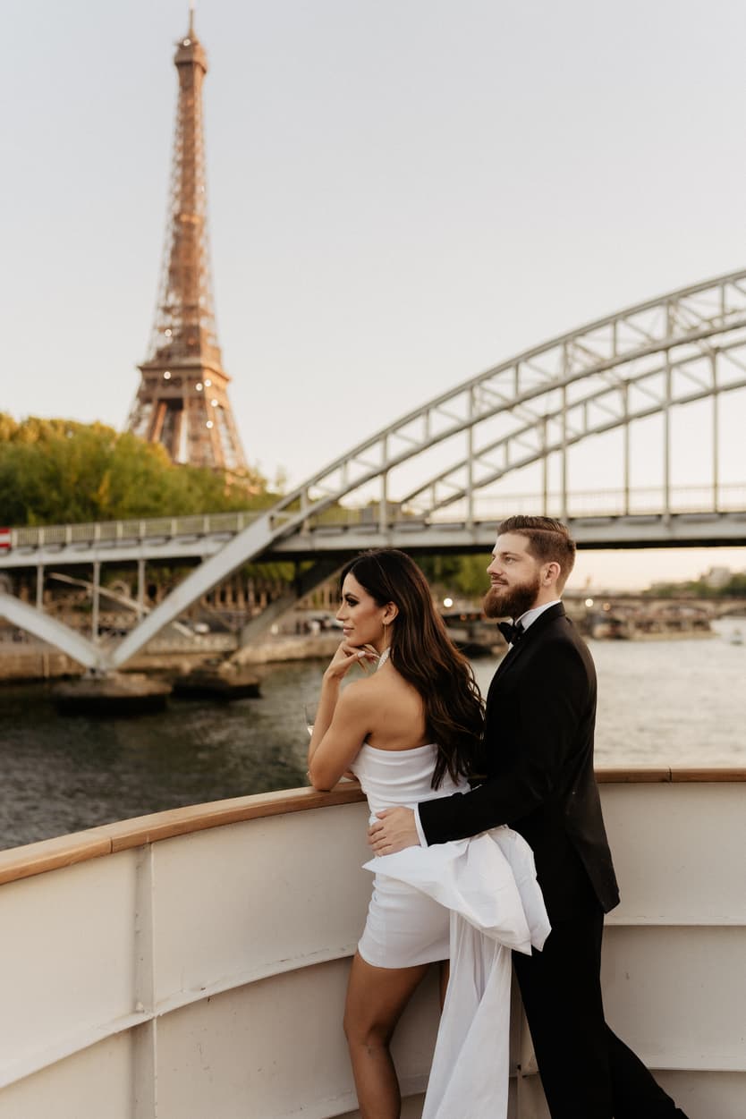 The couple on deck with the Eiffel Tower and the Debilly footbridge behind them
