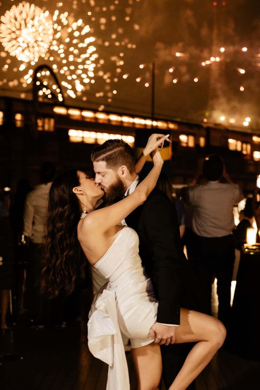 The bride dancing with the groom under the fireworks at the welcome dinner