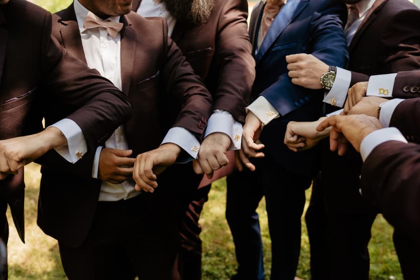 The groomsmen’s gold cufflinks, each with his own initials, held out together