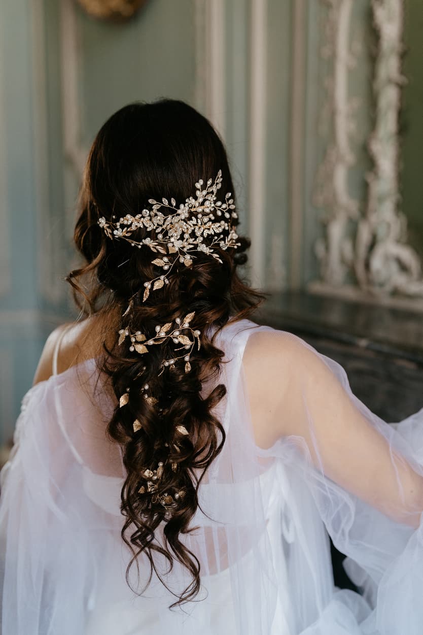 Gold branches and leaves pinned through the bride’s curls, her tulle robe over her shoulders