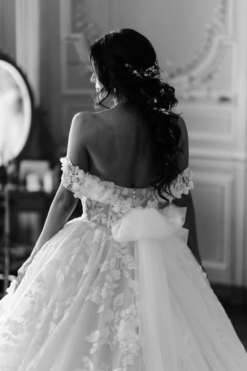 The floral appliqué across the back of the off-shoulder wedding dress, in black and white