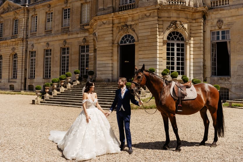 Bride and groom walking the horse across the court after the first look