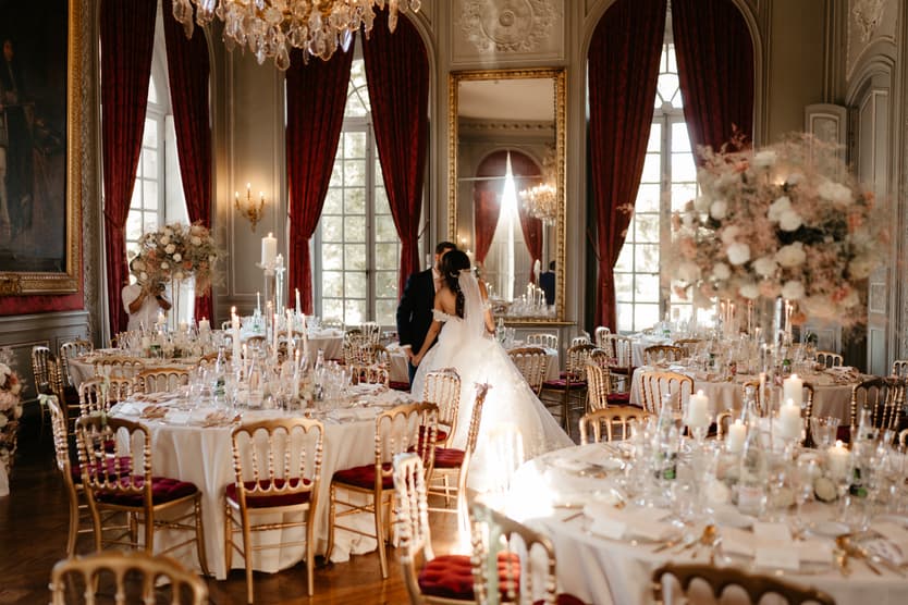 The couple alone among the laid tables of the château reception