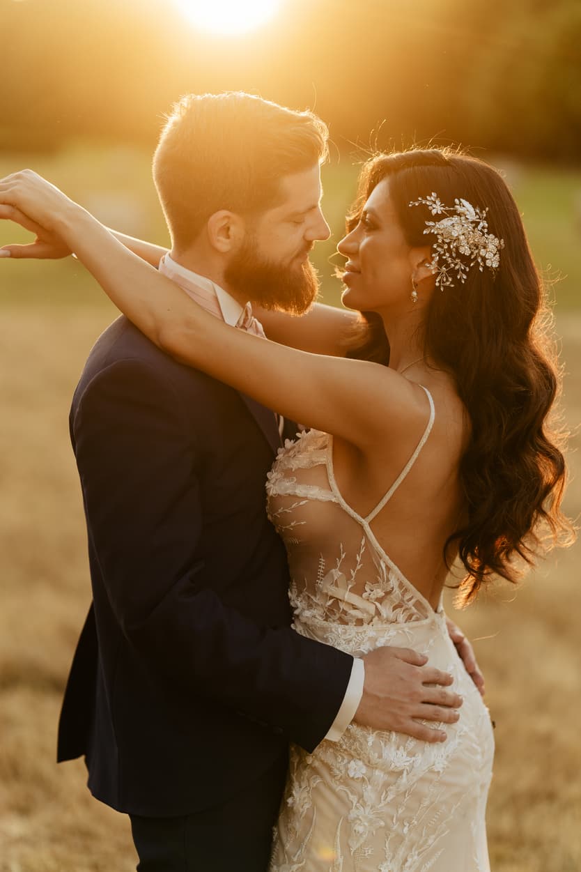 Her hand with the wedding ring on the groom’s chest, the lace of the second gown beneath