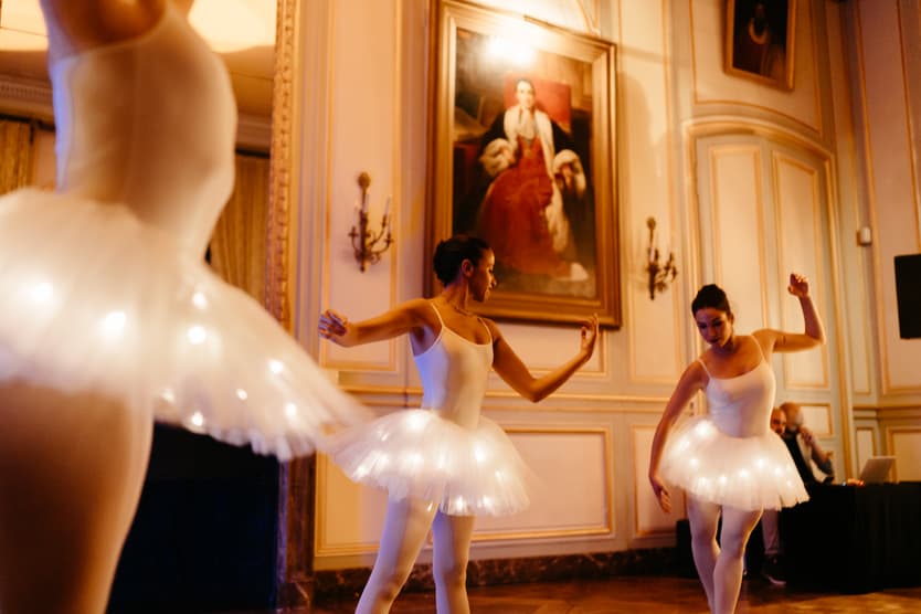 Ballerinas in lit tutus dancing in the salon of the château after dinner