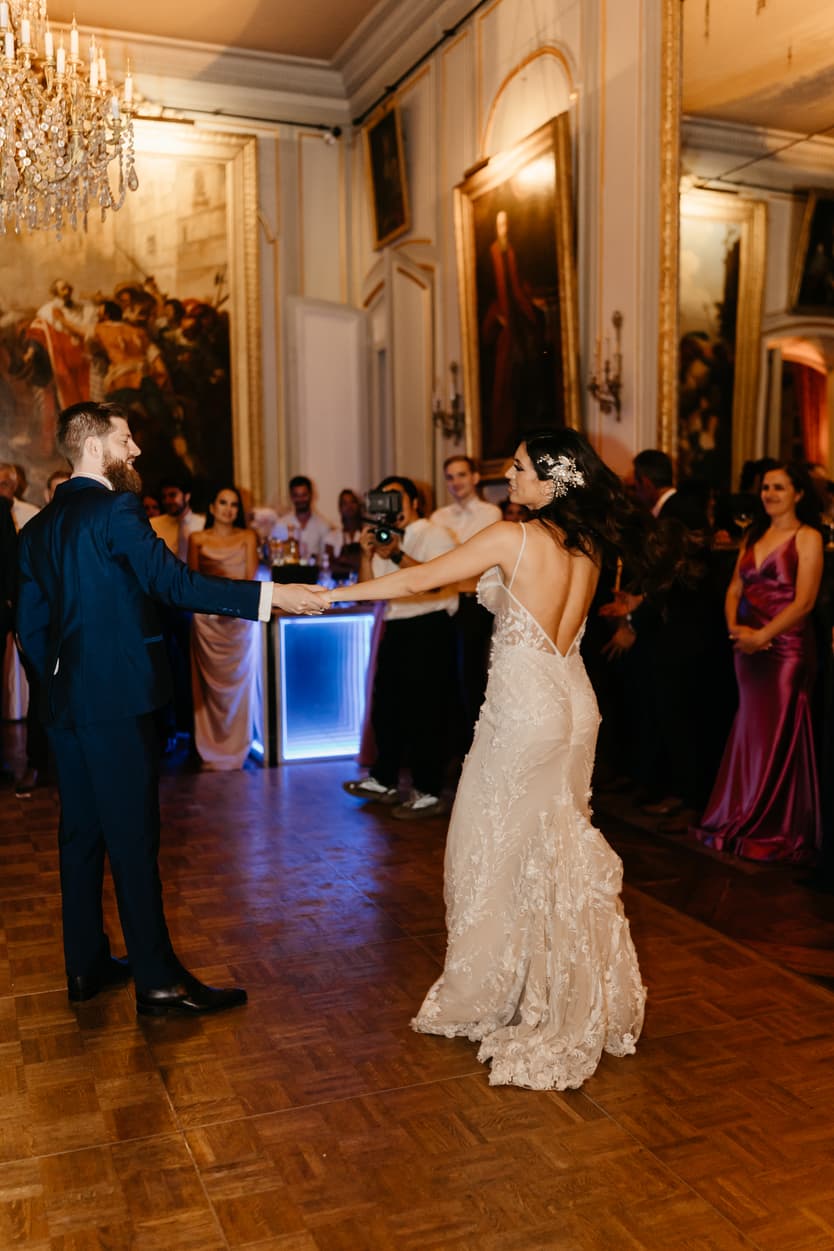 Bride and groom in their first dance under the chandelier of the château