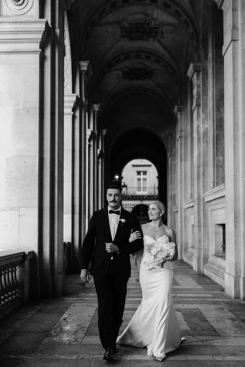 Destination elopement wedding Paris Louvre hallway couple walking 