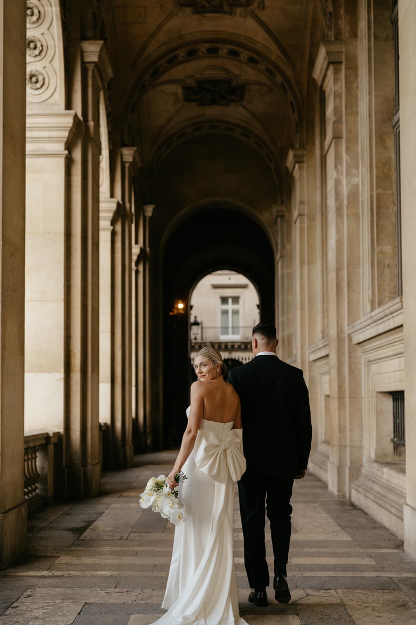 Destination elopement wedding Paris Louvre hallway couple walking 