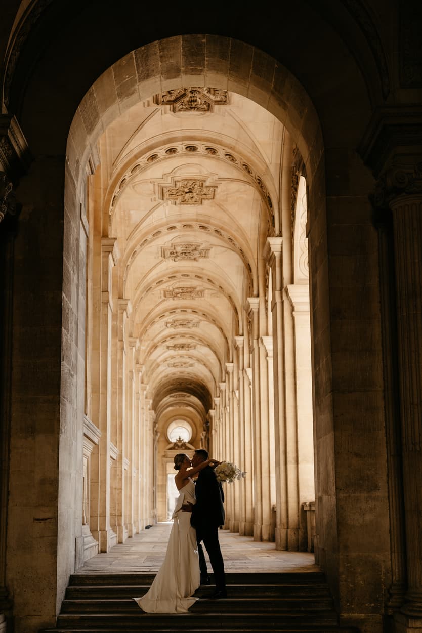 Destination elopement wedding Paris Louvre hallway couple kissing