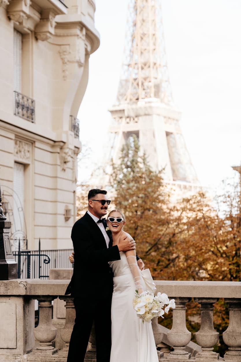 Destination elopement wedding Paris street with Eiffel Tower view couple laughing 