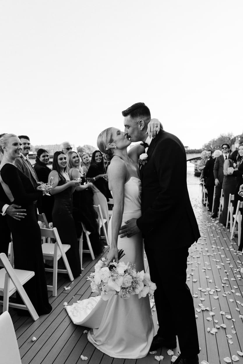 Destination elopement wedding Paris yacht ceremony with Eiffel Tower backdrop couple kissing 