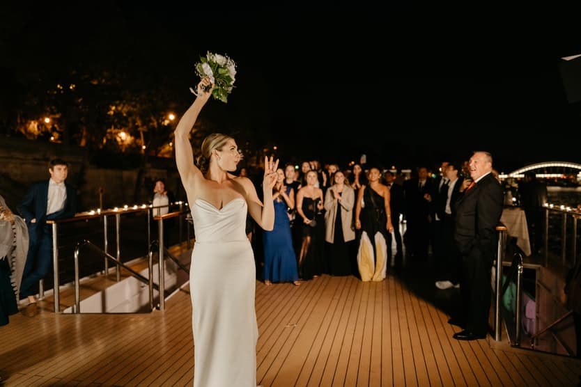 Destination elopement wedding Paris yacht bouquet toss