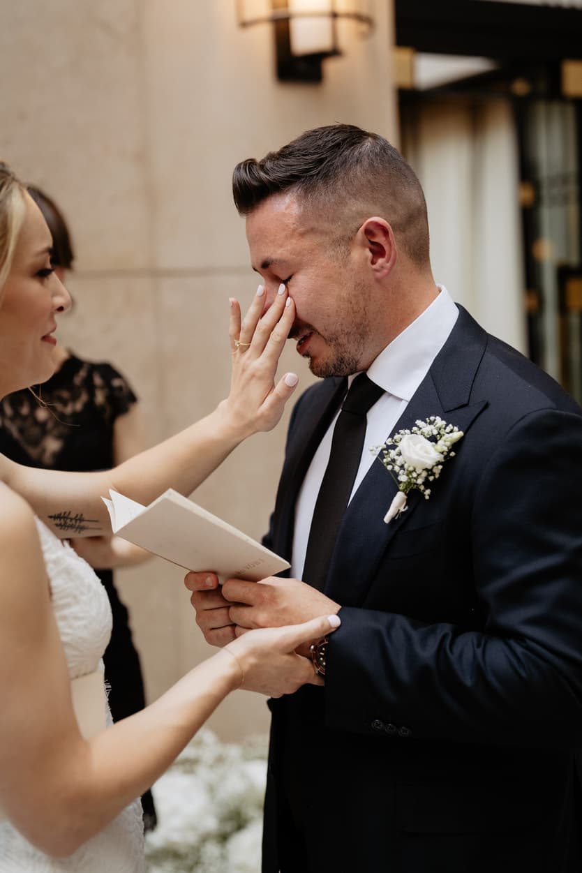 Emotional crying groom reading vows