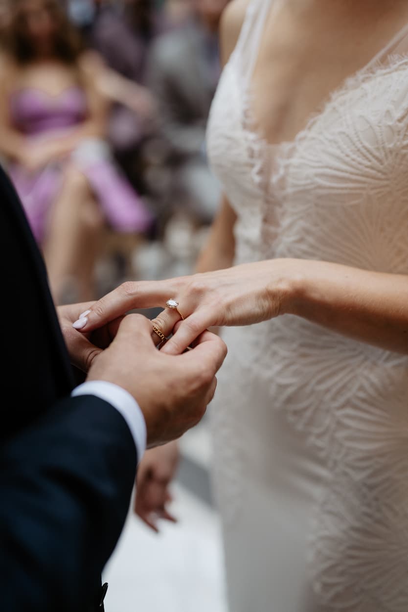 groom and bride happily exchanging wedding ring