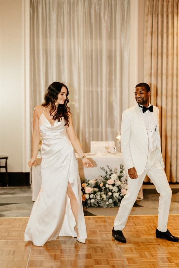 Black groom and white bride do iconic dancing entrances to dinner party