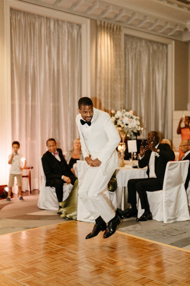 Black groom and white bride do iconic dancing entrances to dinner party