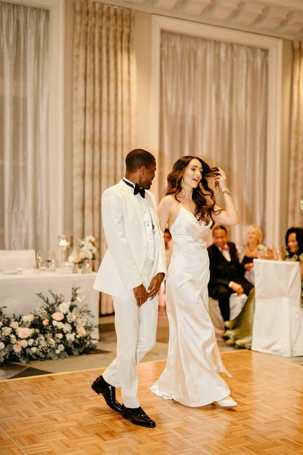 Black groom and white bride do iconic dancing entrances to dinner party