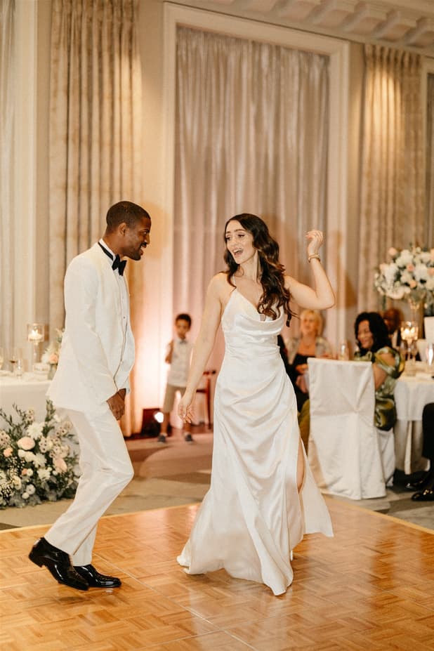 Black groom and white bride do iconic dancing entrances to dinner party