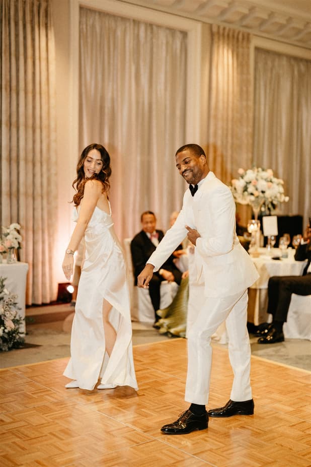 Black groom and white bride do iconic dancing entrances to dinner party