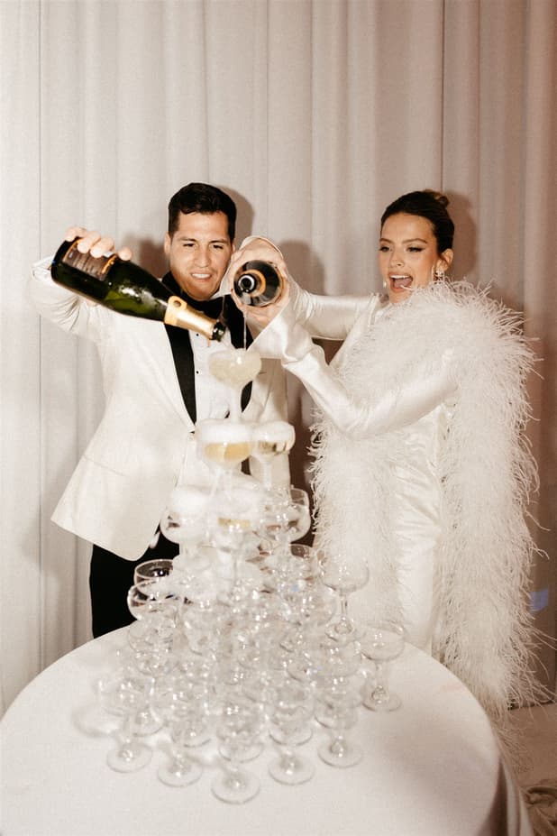Groom and Bride celebrates with champagne tower and raise a toast