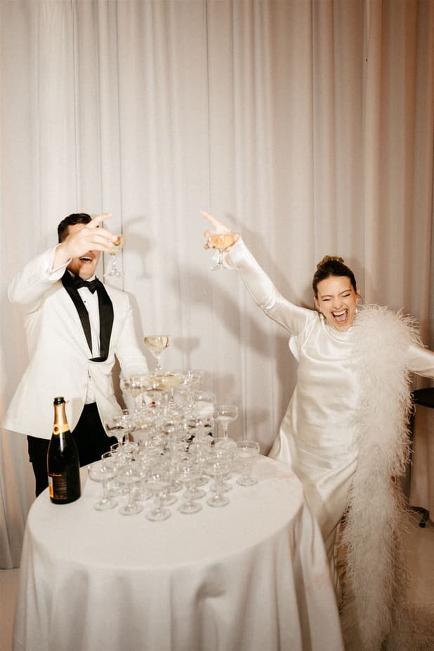 Groom and Bride celebrates with champagne tower and raise a toast