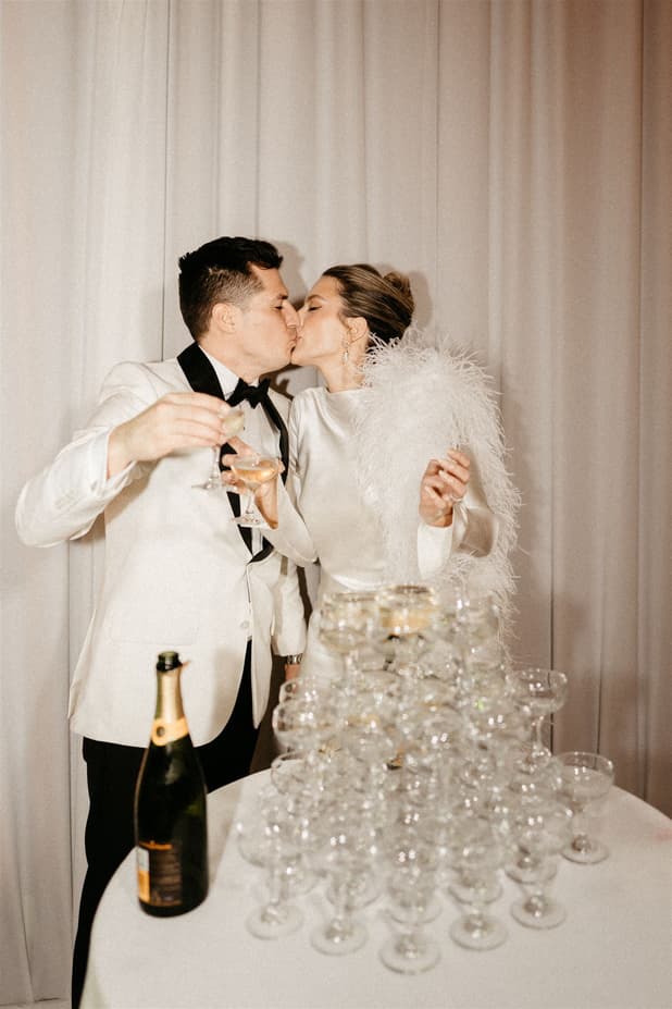 Groom and Bride celebrates with champagne tower and raise a toast