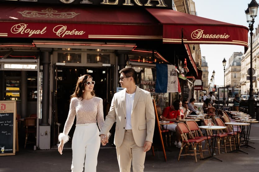 paris pre-wedding couple photoshoot at a red cafe bride wearing cool glasses drinking champagne