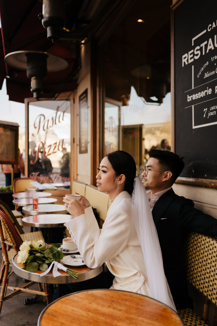Bride and groom drinking café in a romantic sunset paris photoshoot