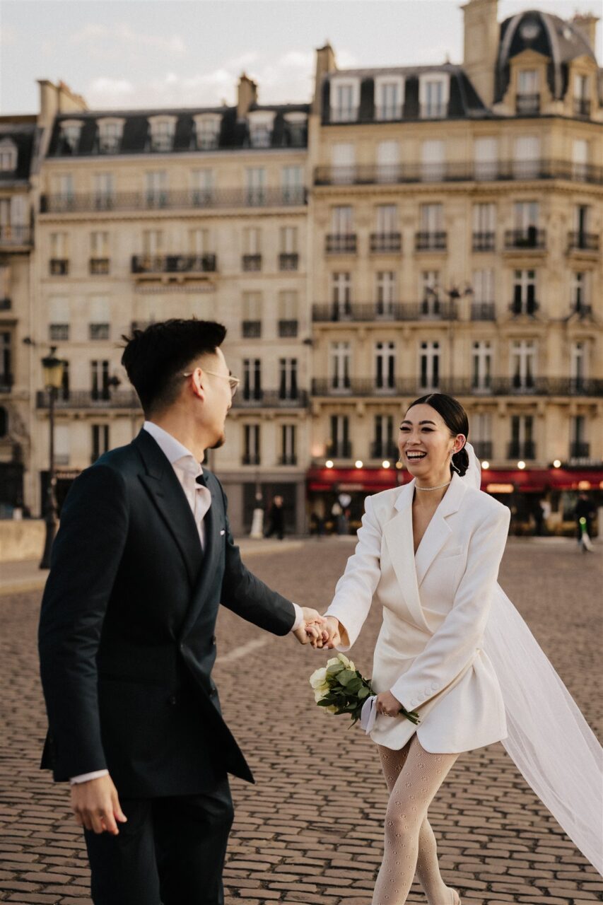 Couple running down the streets of paris romantic pre-wedding