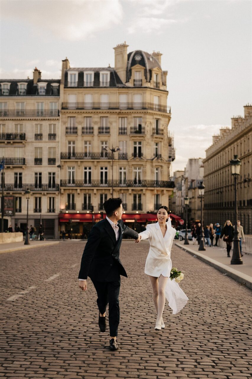 Couple running down the streets of paris romantic pre-wedding