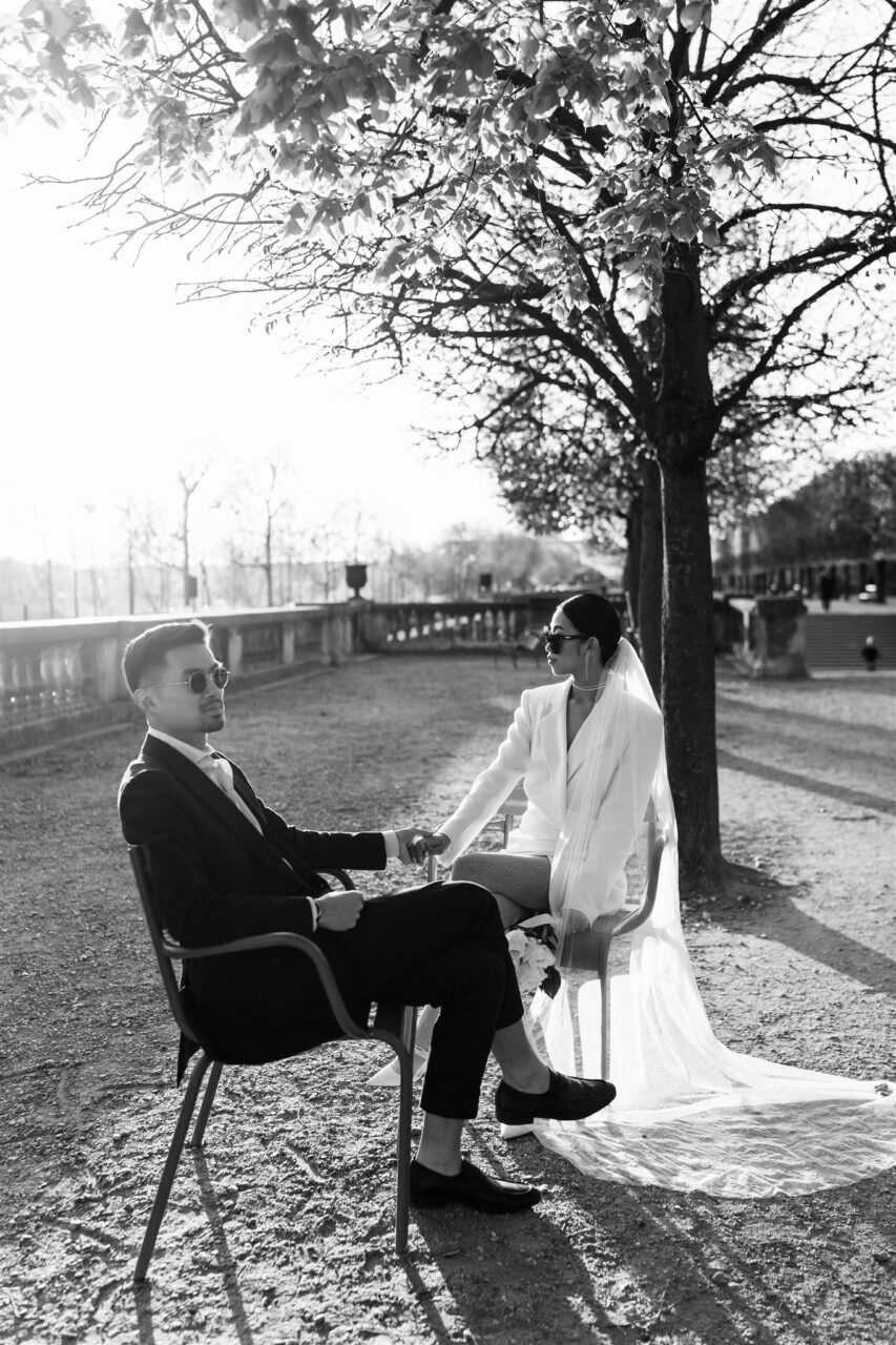 Black and white of a couple sitting down in jardin tuileries paris pre-wedding