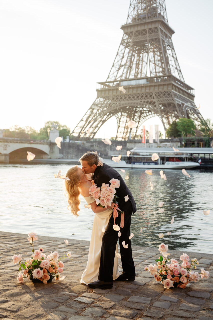Bride and groom kissing during petals shower in an old hollywood elopement in Paris