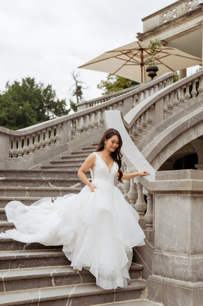 Bride descend stairs at Château Bouffémont