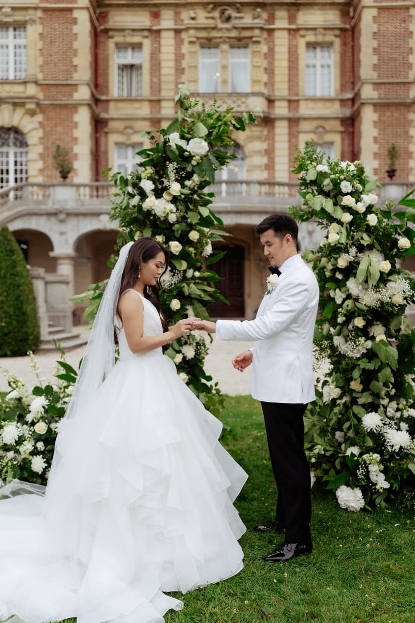 Bride and groom exchanging ring at their destination wedding in Château Bouffémont