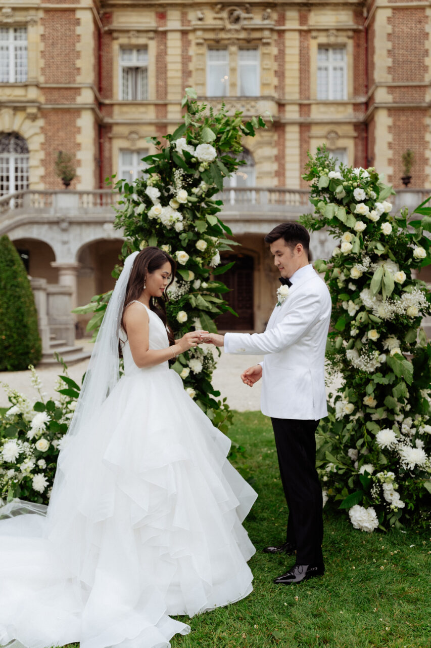 Bride and groom exchanging ring at their destination wedding in Château Bouffémont