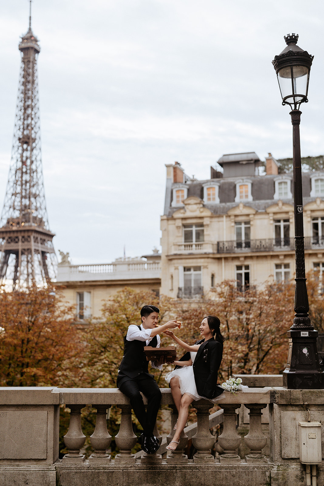 couple eating pizza in front of eiffel tower