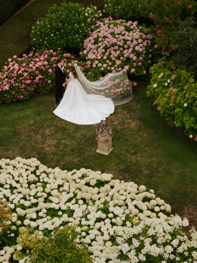 The couple from straight above among the hydrangea beds in the gardens of Château du Grand Lucé